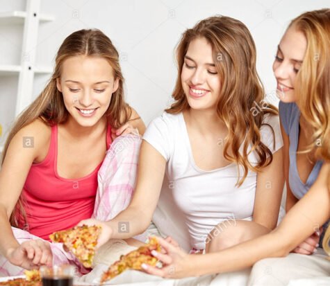 happy-friends-or-teen-girls-eating-pizza-at-home-FXW5J3